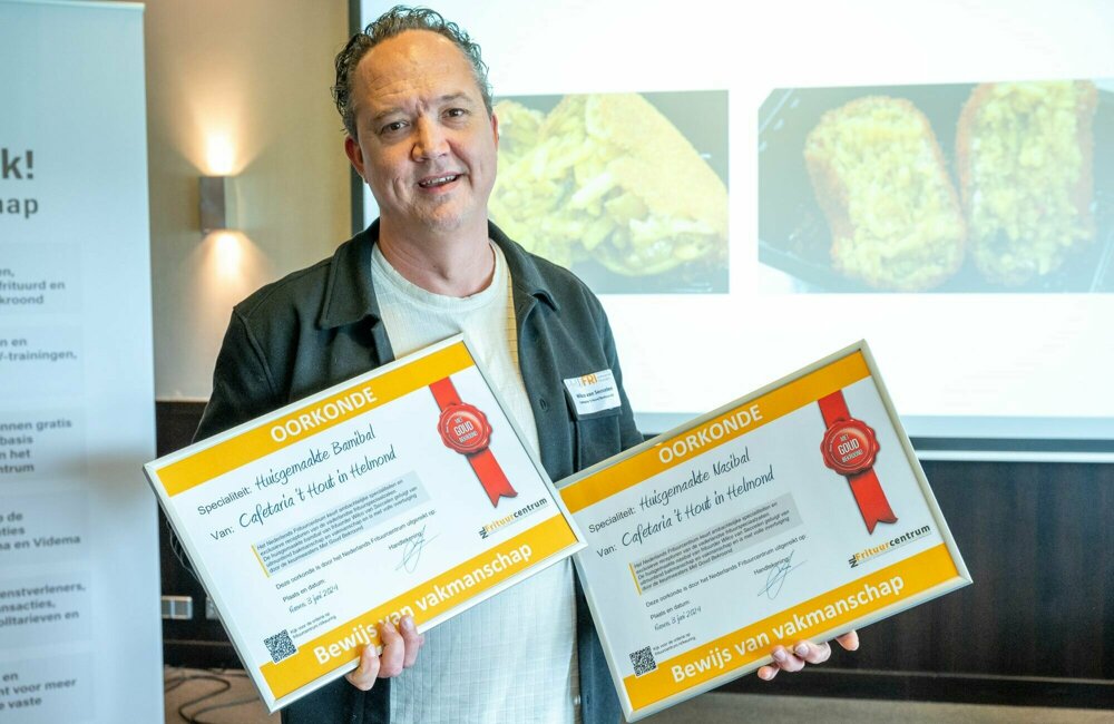Frituurcentrum - Wilco van Seccelen met oorkondes voor gouden bami- en nasibal.jpg