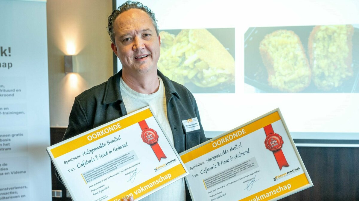 Frituurcentrum - Wilco van Seccelen met oorkondes voor gouden bami- en nasibal.jpg